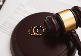Divorce concept with gavel and wedding rings